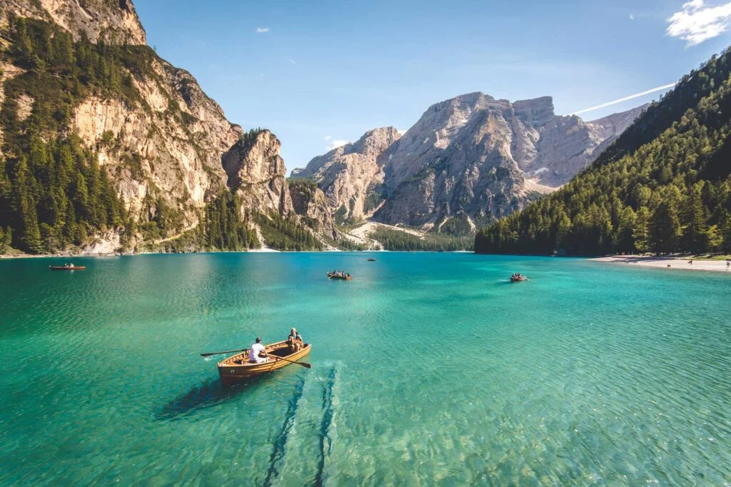Ocean scene with moving boats and distant mountains, symbolizing life direction, personal growth, and the journey to Stop Chasing Echoes and follow your own path.